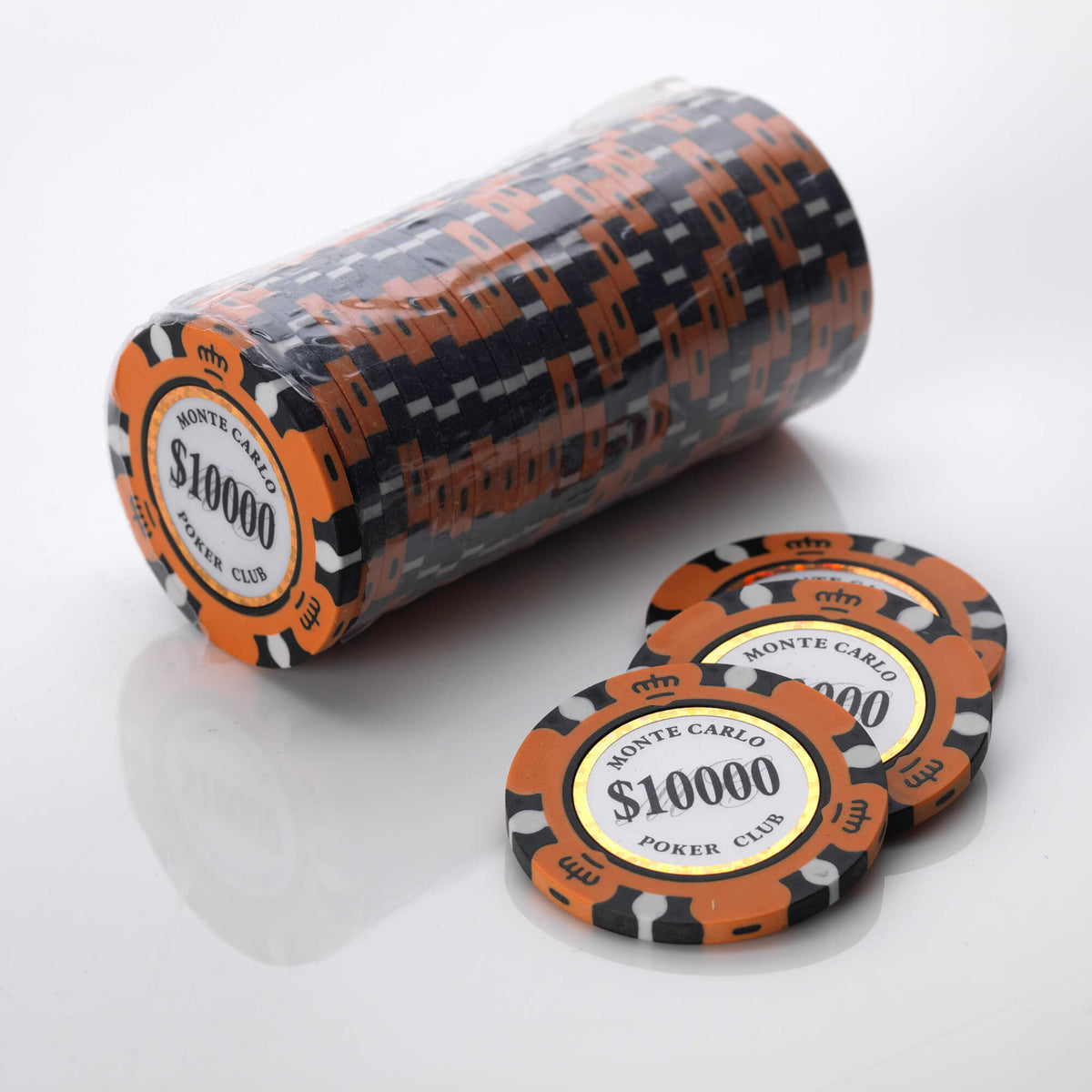 Wrapped roll of orange and black Monte Carlo poker chips with three loose chips in front of it