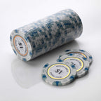 Wrapped roll of white and blue Monte Carlo poker chips with three loose chips in front of it