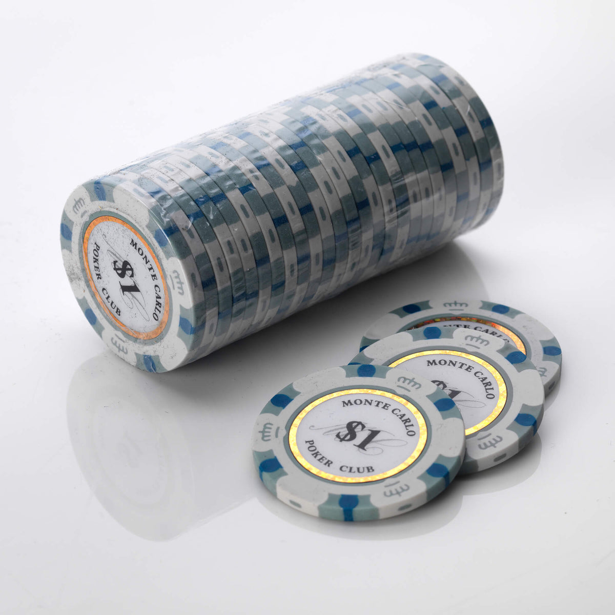 Wrapped roll of white and blue Monte Carlo poker chips with three loose chips in front of it