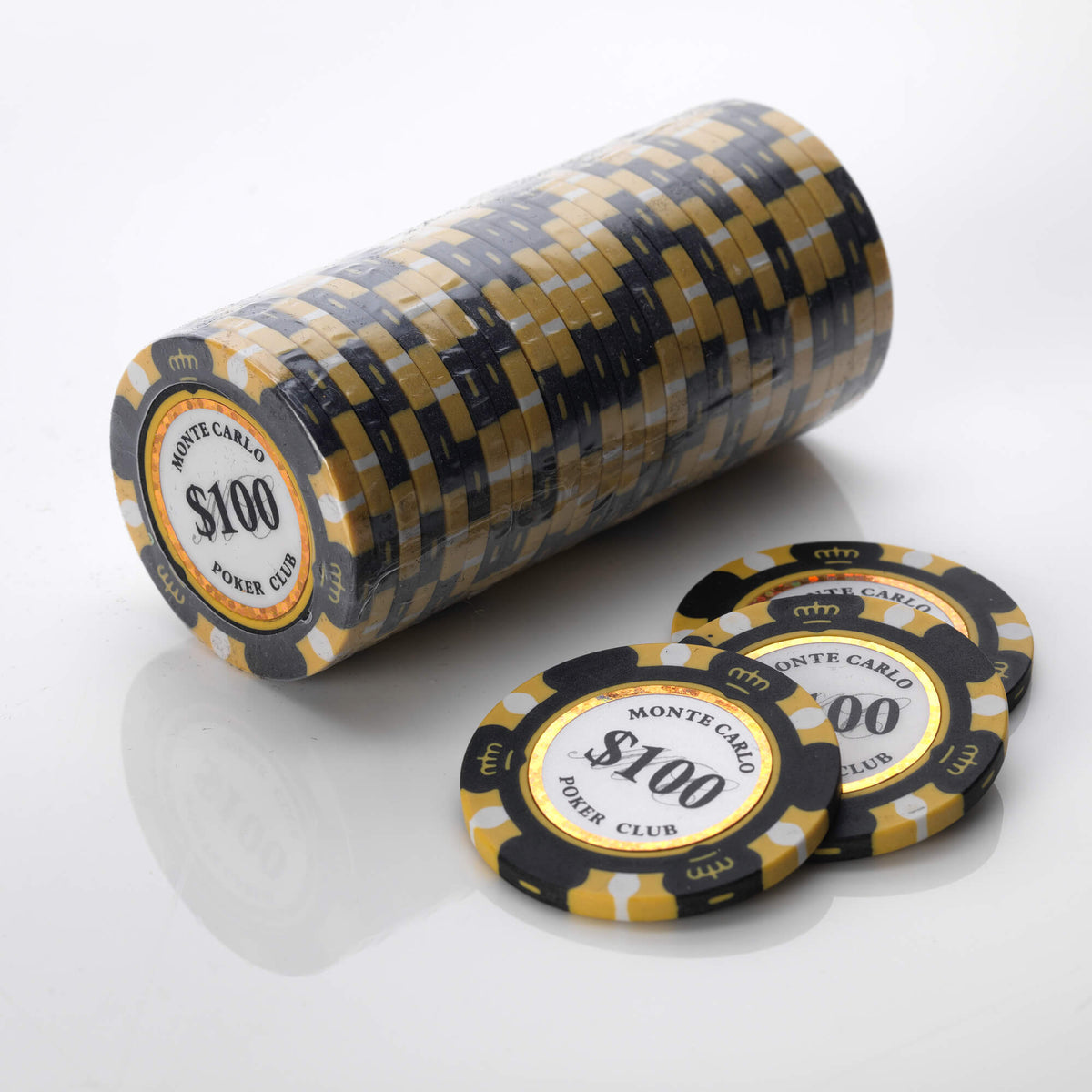 Wrapped roll of black and gold Monte Carlo poker chips with three loose chips in front of it