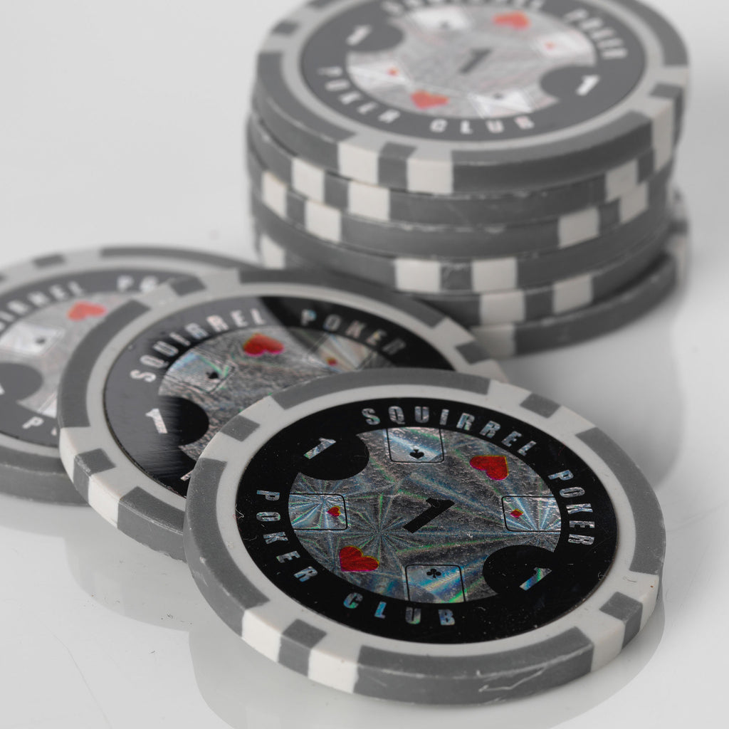 Close-up of a stack of black and grey Squirrel Poker Club poker chips with playing card suit designs