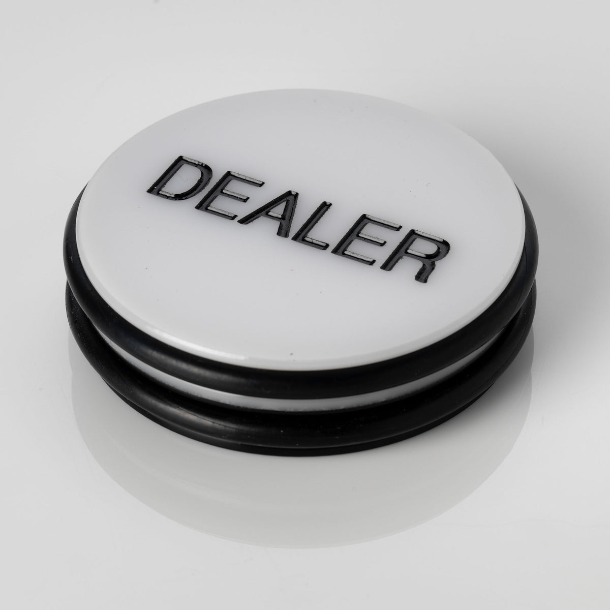 Large white 3 inch poker dealer button with DEALER printed in black lettering