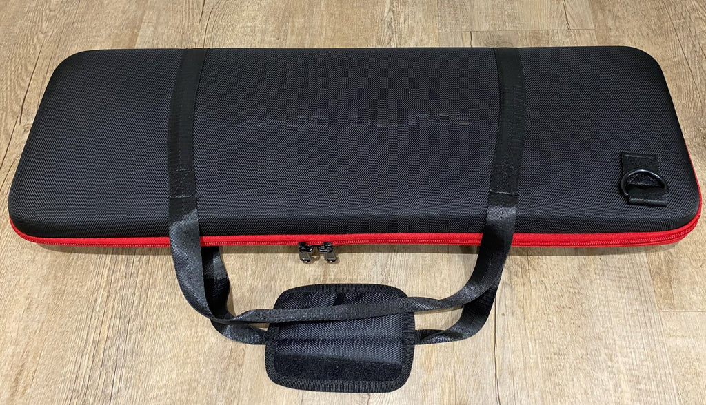 Closed black EVA poker chip case with red trim and carry handles, with a small pouch in front