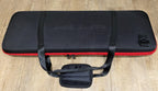 Closed black EVA poker chip case with red trim and carry handles, with a small pouch in front