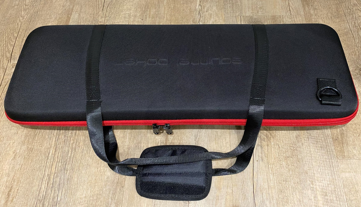 Closed black EVA poker chip case with red trim and carry handles, with a small pouch in front