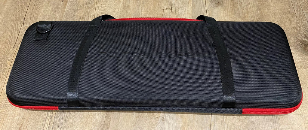 Closed black EVA poker chip case with red trim and two carry straps, seen from above