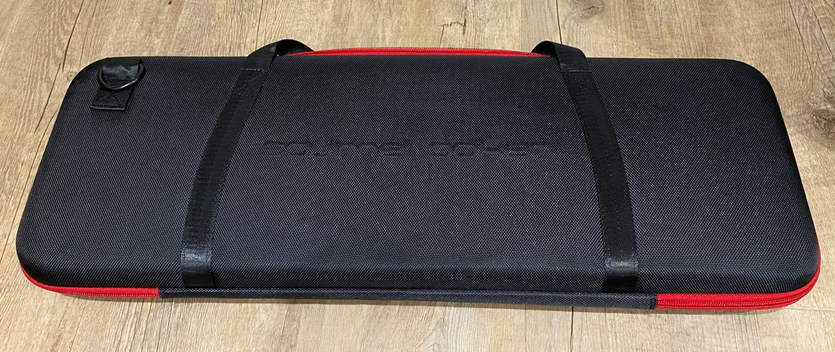 Closed black EVA poker chip case with red trim and two carry straps, seen from above