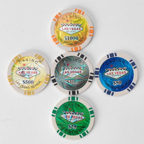 Five Las Vegas style casino poker chips in different colours and denominations arranged in a flower pattern on a white background