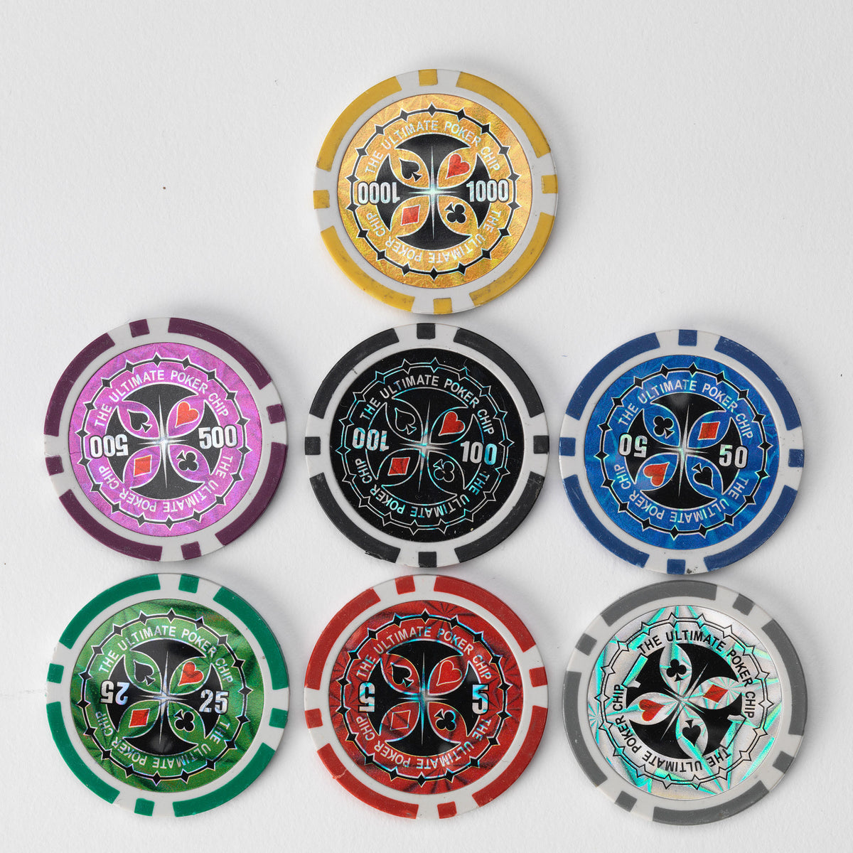 Seven Ultimate poker chips in pink, black, blue, green, red, yellow and grey, arranged in a pyramid on a white background