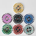 Seven Ultimate poker chips in yellow, pink, black, blue, green, red and grey arranged on a white background